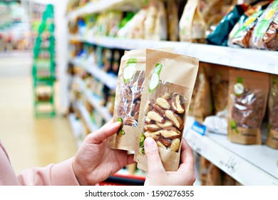 Woman With Pecan And Brazil Nuts In Store