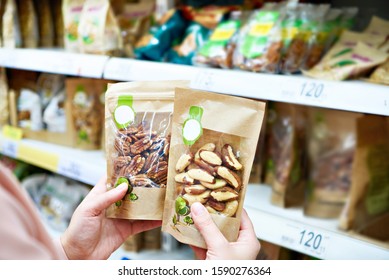 Woman With Pecan And Brazil Nuts In Store