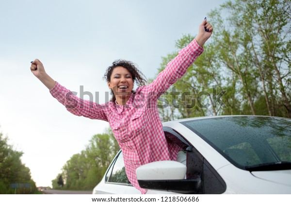 Woman peeking out of car window, woman peeking\
out of window and waving her\
hand