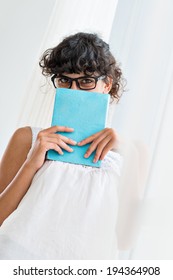 Woman Peeking Over A Top Of Her Book