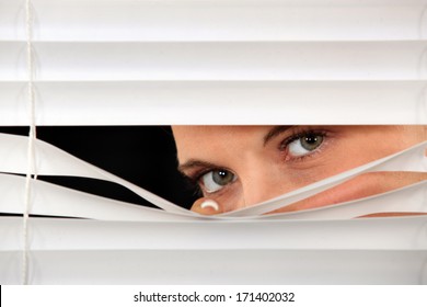 Woman Peeking Through  Blinds