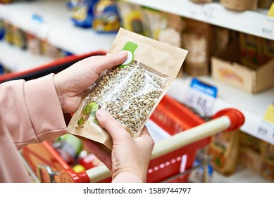 Woman With Peeled Sunflower Seeds In The Store