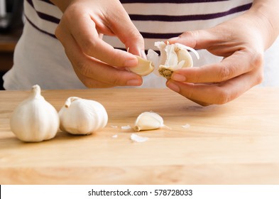 Woman peeling garlic by hand for cooking - Powered by Shutterstock