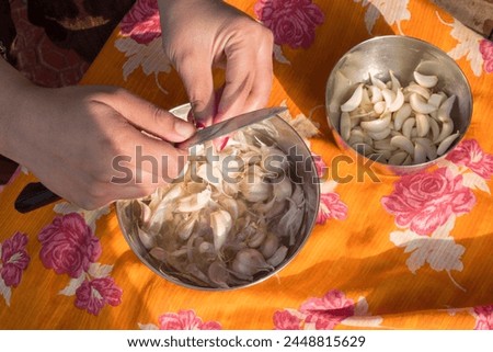 Woman peeling garlic by hand for cooking homemade food