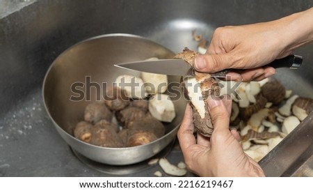 A woman peeling a Japanese taro.