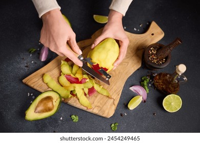 Woman peeling mango on a wooden cutting board at domestic kitchen - Powered by Shutterstock