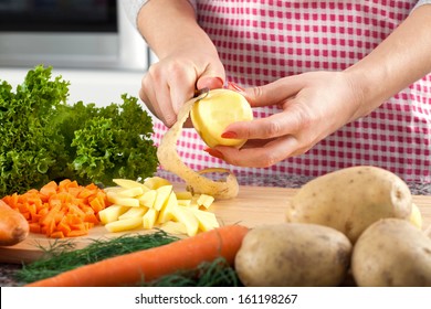 Woman Is Peeling Potato And Preparing Dinner For Family