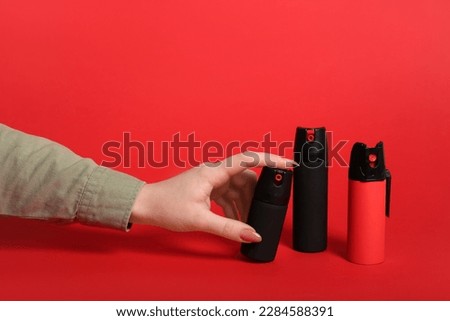 Woman with pepper sprays on red background