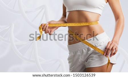Woman with perfect body near DNA stems. Slimming concept. Improvement of metabolism concept.