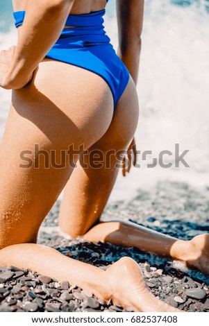Woman with perfect body relax in sea, wearing stylish blue bikini