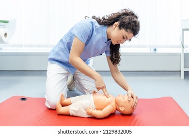 Woman performing CPR on baby training doll with one hand compression. First Aid Training - Cardiopulmonary resuscitation. First aid course on cpr dummy. - Powered by Shutterstock