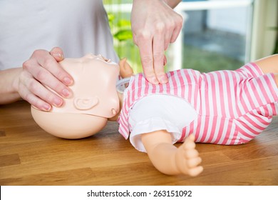 woman performing CPR on baby training doll with one hand compression - Powered by Shutterstock