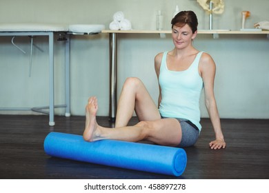 Woman Performing Exercise Using Foam Roll In The Clinic