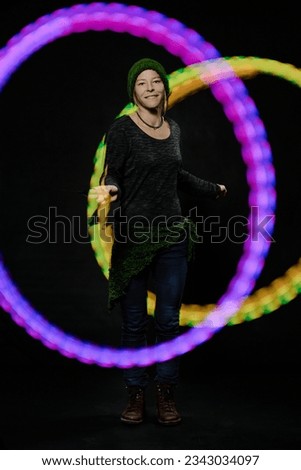 Woman performing glow stringing poi juggle with led ball