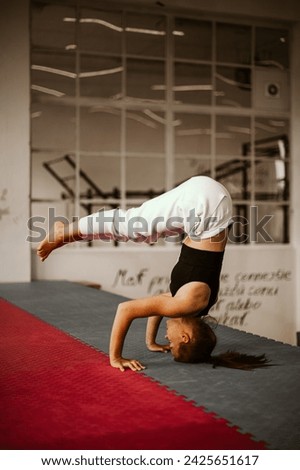 Similar – Image, Stock Photo Flexible woman performing headstand pose in yoga studio