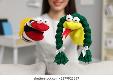 Woman performing puppet show at home, selective focus