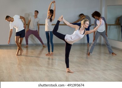 Woman performing stretching exercise in fitness studio - Shutterstock ID 491393674