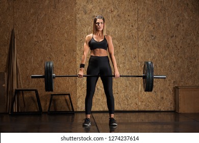 Woman performs deadlift with weight in the gym