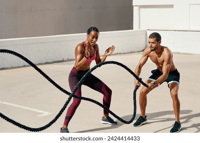 Woman, personal trainer and battle rope for workout, exercise or training in fitness outdoors. Fit, active or serious coaching with man person exercising with ropes for sports endurance or motivation - Powered by Shutterstock