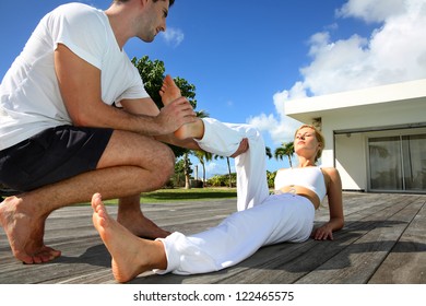 Woman With Personal Trainer Exercising Outside