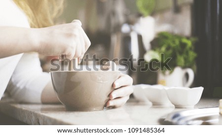 A woman pestling ingredients in a bowl, cooking a dessert. Ingredients in a rounded bowl to cook a dessert