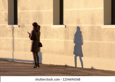 Woman With Phone And Shadow On The Wall