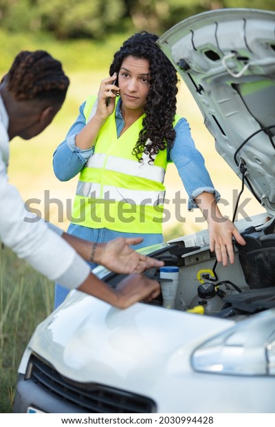 woman phones\
for assistance after car\
breakdown