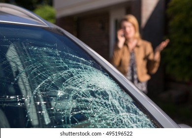Woman Phoning For Help After Car Windshield Has Broken - Shutterstock ID 495196522