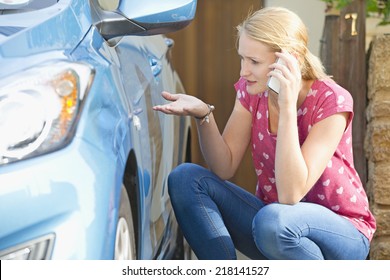 Woman Phoning Insurance Company To Report Car Damage