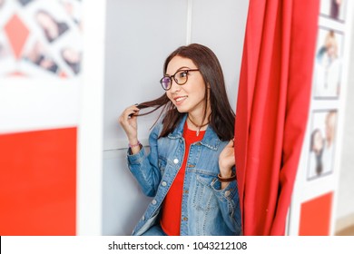 A Woman Is Photographed And Amused In A Photo Booth, Making Istant Selfie Photos For Fun Or For Passport And Documents