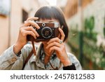 woman photographer with a camera takes pictures outdoors. A young female photographer aims the lens and enjoys the process of shooting. travel to Arab countries. travel and vacation.