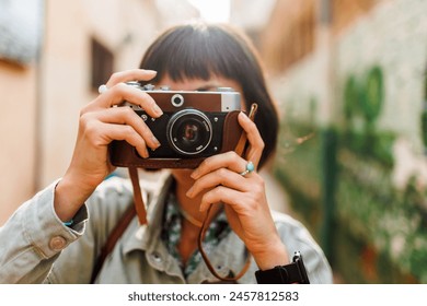 woman photographer with a camera takes pictures outdoors. A young female photographer aims the lens and enjoys the process of shooting. travel to Arab countries. travel and vacation. - Powered by Shutterstock