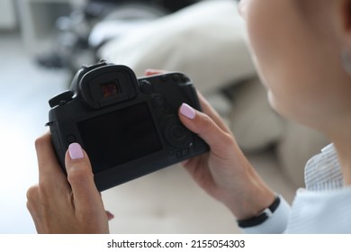 Woman photographer go through pics on camera backstage after photoshot