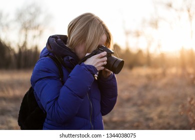 A Woman Photographer Holds A Camera In Her Hands. The Concept Of A Woman Photojournalist.