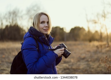 A Woman Photographer Holds A Camera In Her Hands. The Concept Of A Woman Photojournalist.