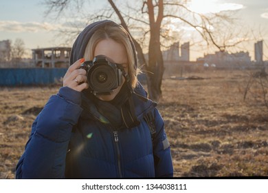 A Woman Photographer Holds A Camera In Her Hands. The Concept Of A Woman Photojournalist.