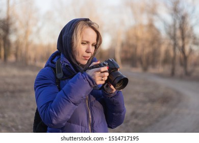 A Woman Photographer Holds A Camera In Her Hands. The Concept Of A Woman Photojournalist.