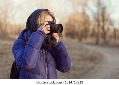 A Woman Photographer Holds A Camera In Her Hands. The Concept Of A Woman Photojournalist.