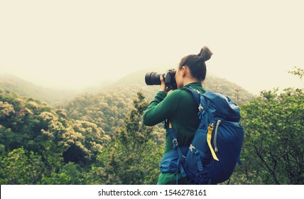 Woman photographer taking photo on spring forest mountain - Powered by Shutterstock