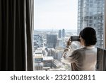 Woman photographing skyline from apartment