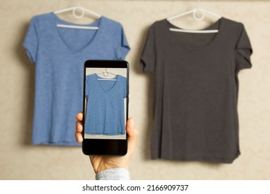A woman photographs clothes on a smartphone. The concept of online shopping, e-commerce. - Shutterstock ID 2166909737
