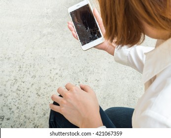 Woman Picking Broken Smart Phone From The Floor