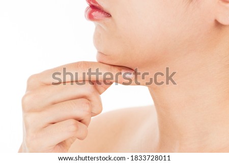 The woman is picking the fat on her chin.