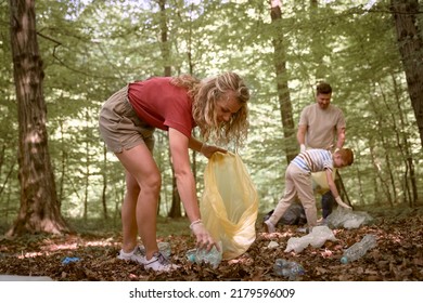 Woman Picking Up Plastic Bottle From Forest 