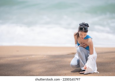 Woman Picking Up Shells And Holding Them In Hand On The Beach.