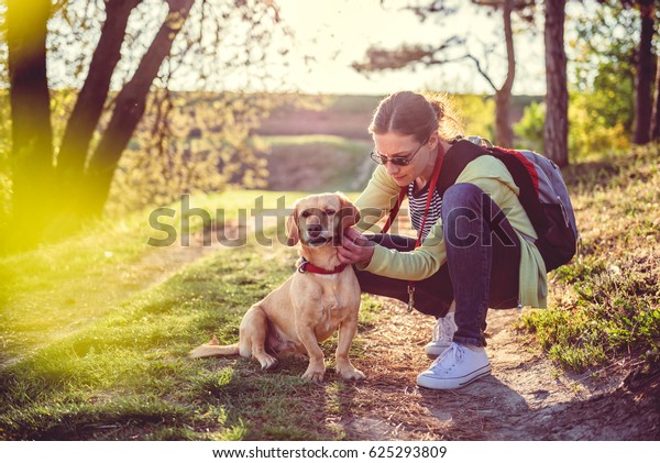 Woman picking a tick on dog\
fur