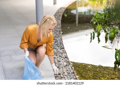 Woman Picking Up Trash Outdoors In The Street In Summer