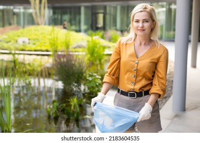 Woman Picking Up Trash Outdoors In The Street In Summer