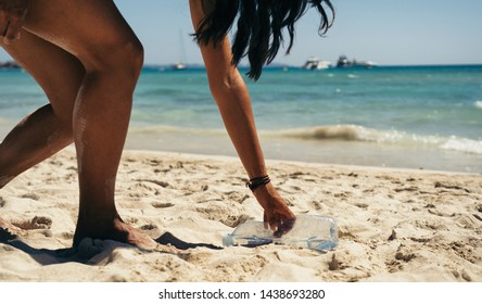 Woman Picking Up A Water Bottle Garbage In The Beach.