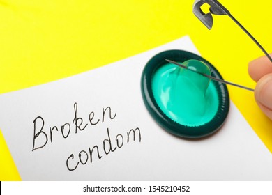 Woman piercing condom with pin on yellow background, above view. Safe sex